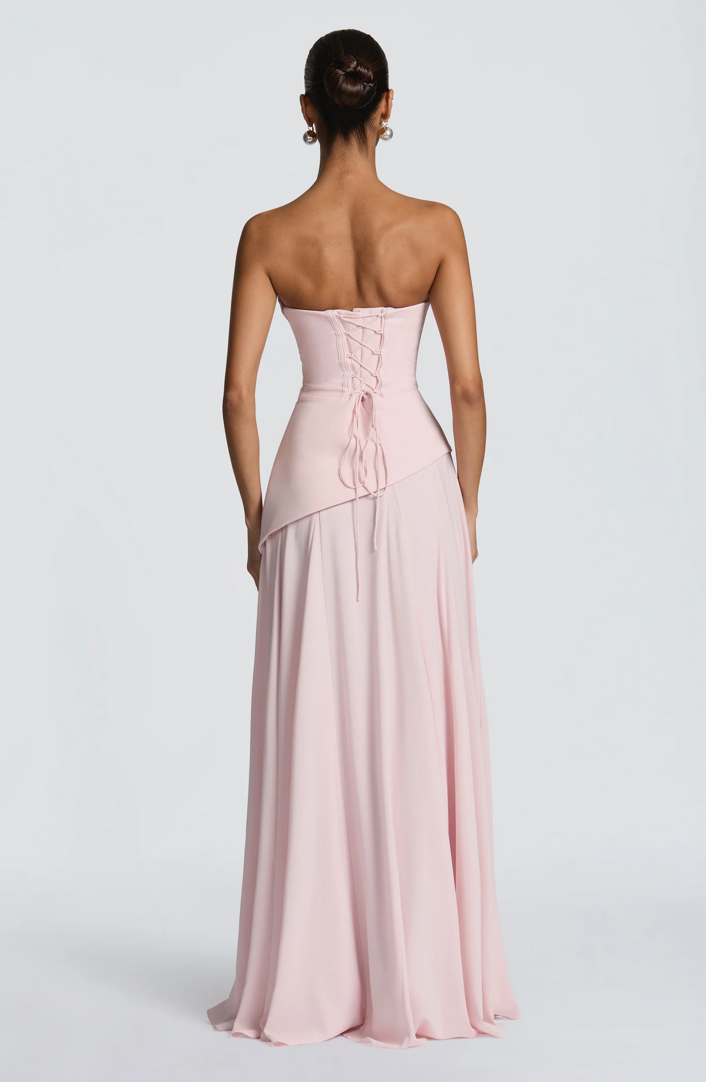 Blush pink strapless maxi dress with lace-up corset back and draped bodice