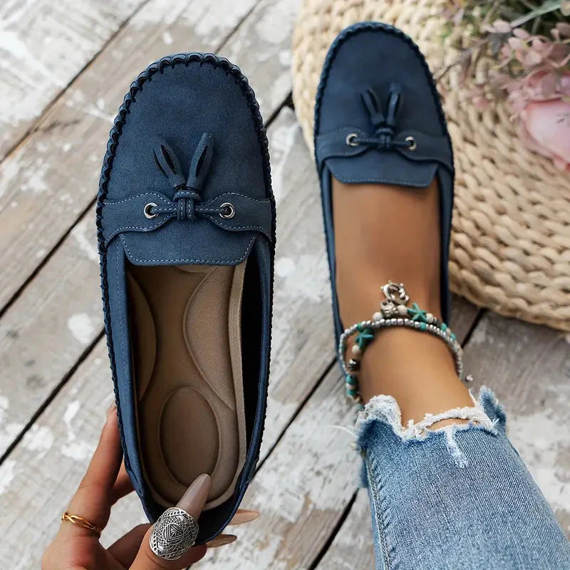 Navy and tan suede bow loafers showing cushioned insole and top view