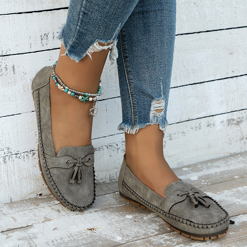 Olive green suede bow loafers with cushioned sole, worn with distressed denim