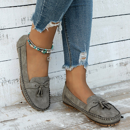 Olive green suede bow loafers with cushioned sole, worn with distressed denim