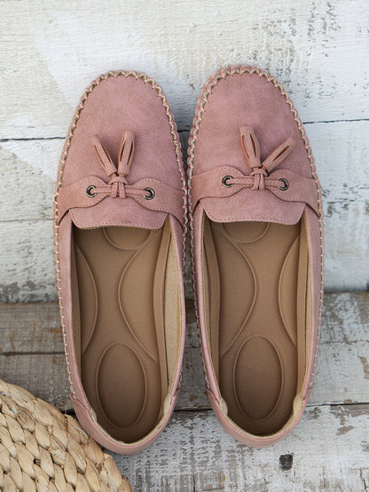 Mauve suede bow loafers pair with cushioned sole, top-down view
