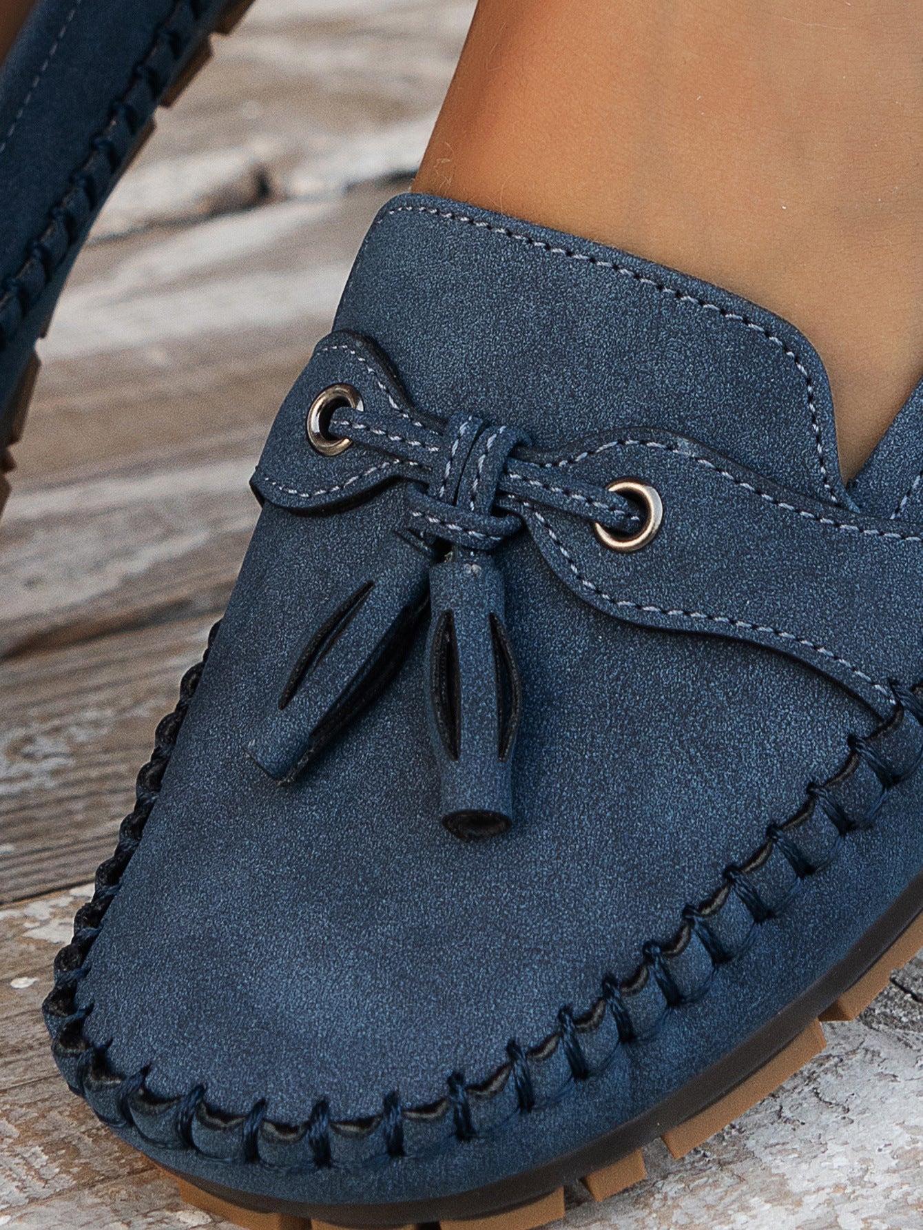 Navy suede bow loafer close-up showing bow tie and stitched sole detail