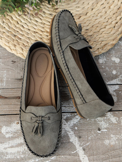 Olive green suede bow loafers pair with cushioned sole and woven basket