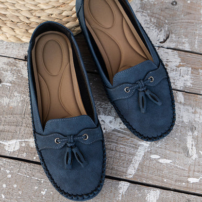 Navy suede loafers with bow detail and cushioned sole, flat lay overhead view