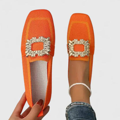 Bright orange knit loafer with gold decorative buckle, shown flat and on foot