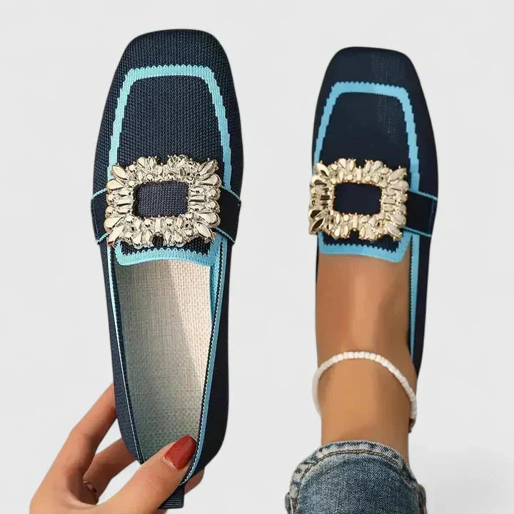 Navy and turquoise knit loafer with gold decorative buckle detail, shown flat and on foot