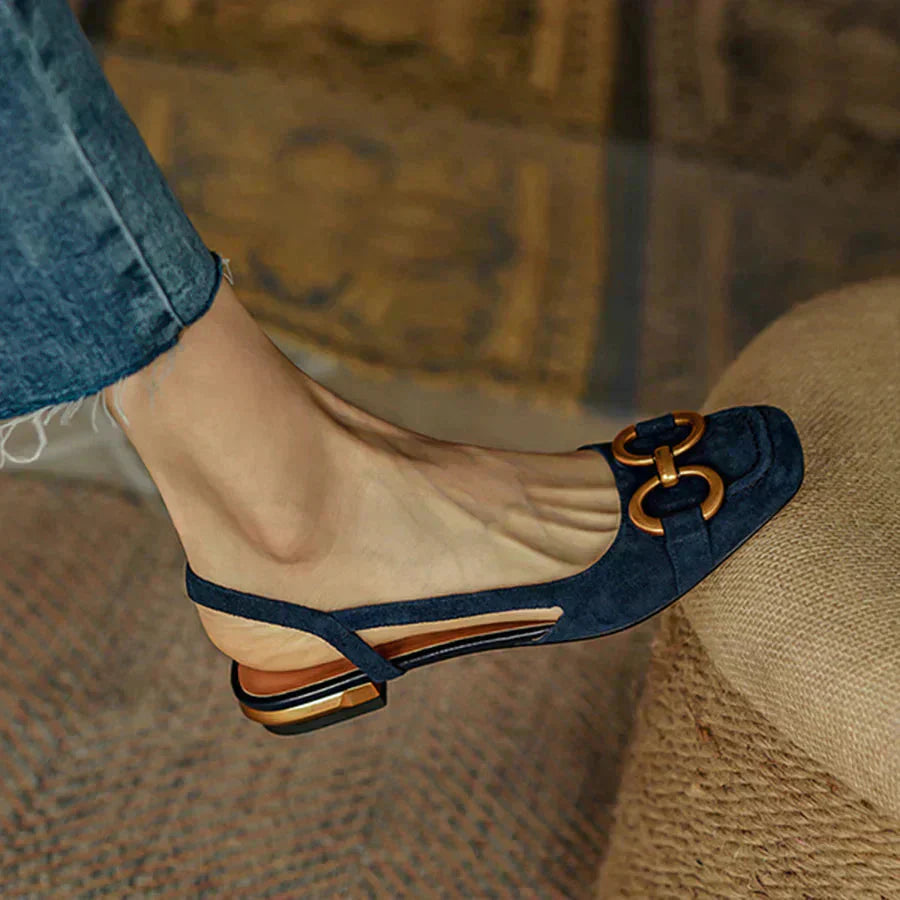 Side view of navy loafer flat showing gold hardware accent and low block heel