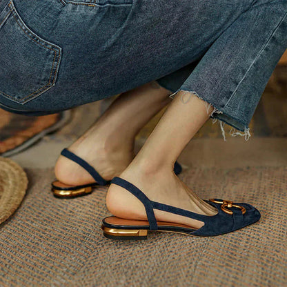 Navy suede loafers with metallic buckle worn casually with ripped denim