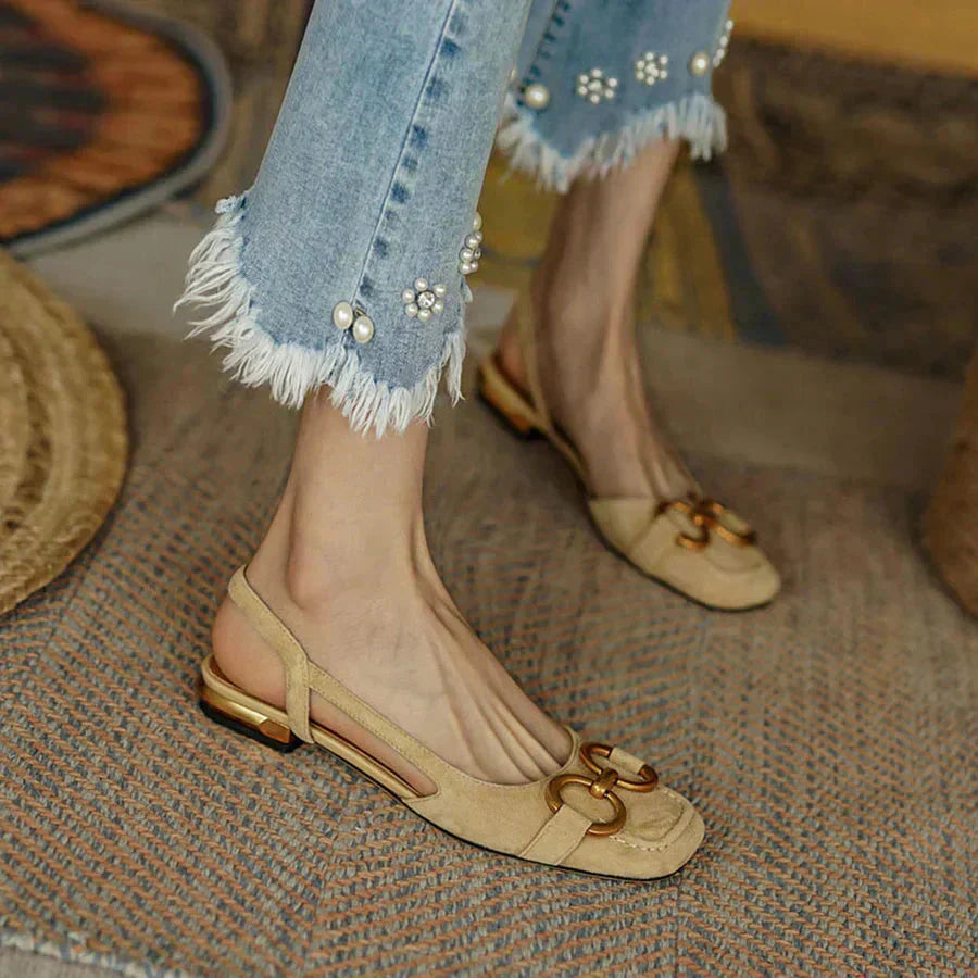 Cream suede loafer flats with gold buckle hardware styled with embellished jeans