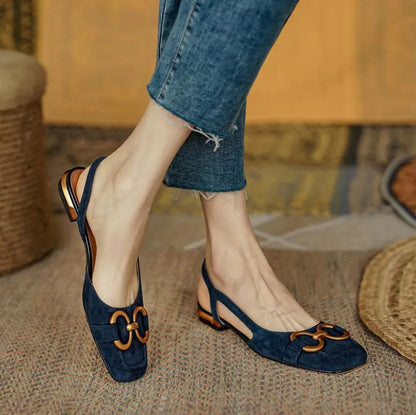 Navy suede loafer flats with gold metal buckle detail worn with distressed jeans