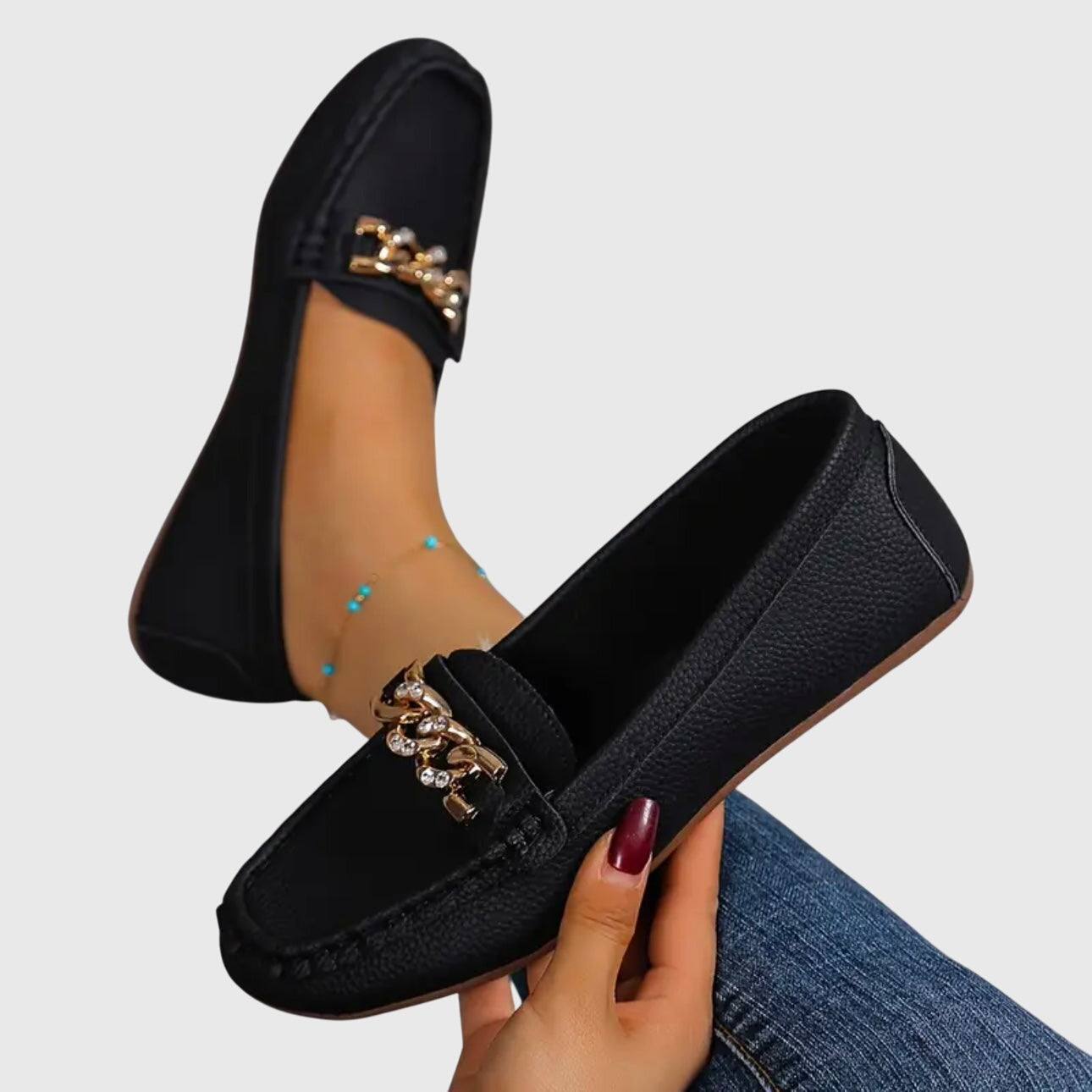 Black chain link loafers with gold hardware detail on vamp