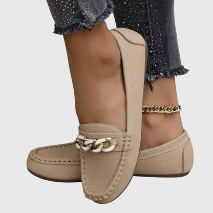 White loafers with rose gold chain link detail on feet