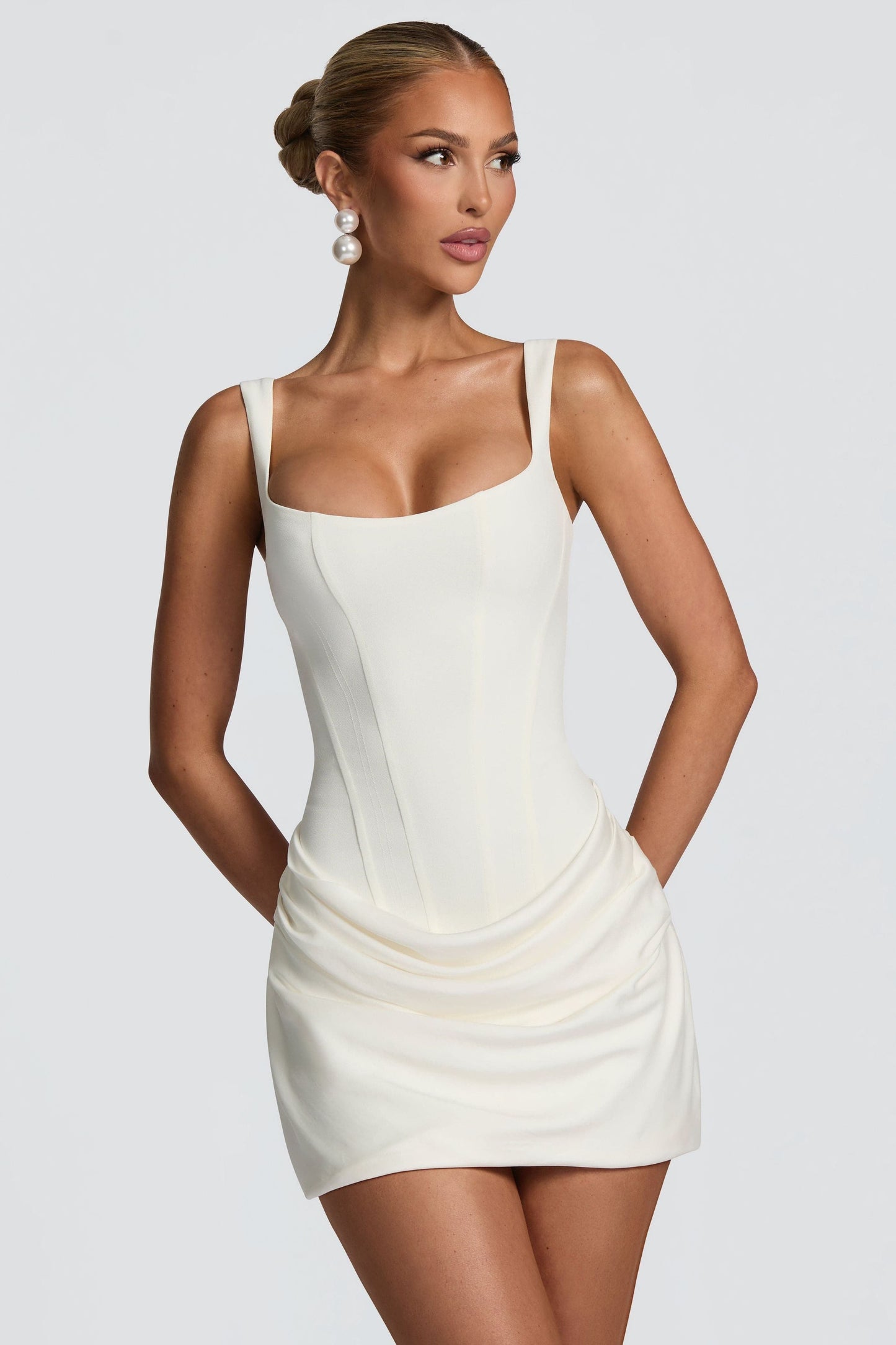 Ivory square neck sleeveless mini dress with draped skirt and pockets