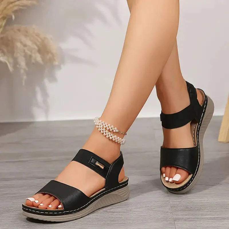 Black adjustable platform sandal with dual ankle straps and contrasting tan sole