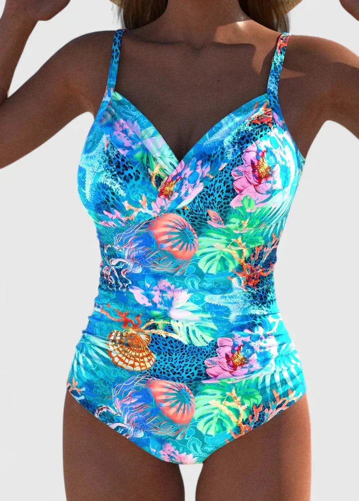 Women's tropical printed one-piece swimsuit with tie-back in bright blue with colorful coral and floral motifs, front view