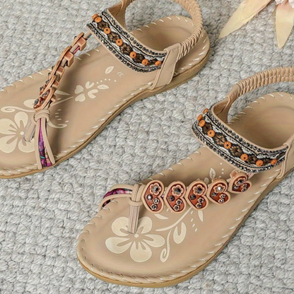 Beige bohemian sandals with white floral embossed design and beaded t-strap ornaments