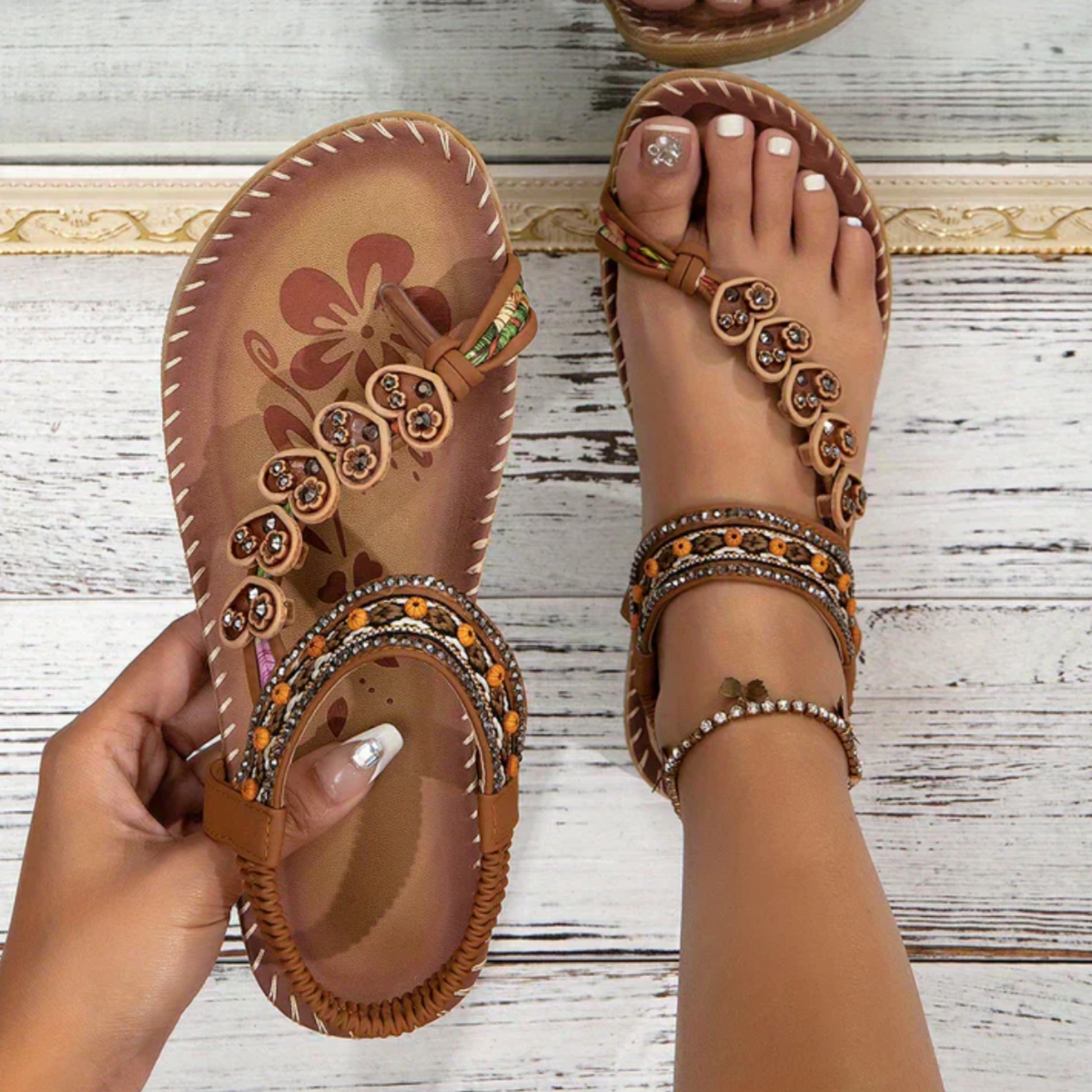 Tan bohemian beaded t-strap sandals with ornate circular charms and rhinestone ankle straps