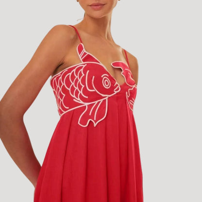 Detailed view of white embroidered fish design on red maxi dress