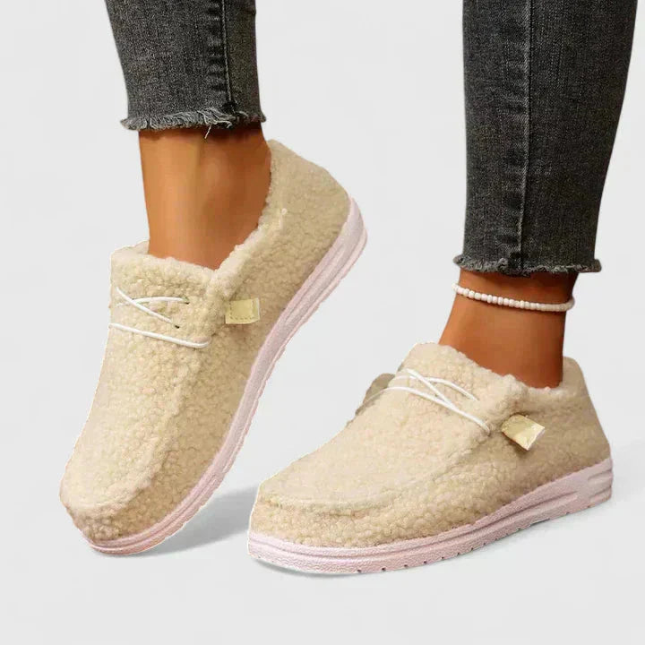 Cream fleece moccasin loafers with pink sole and decorative bow accent