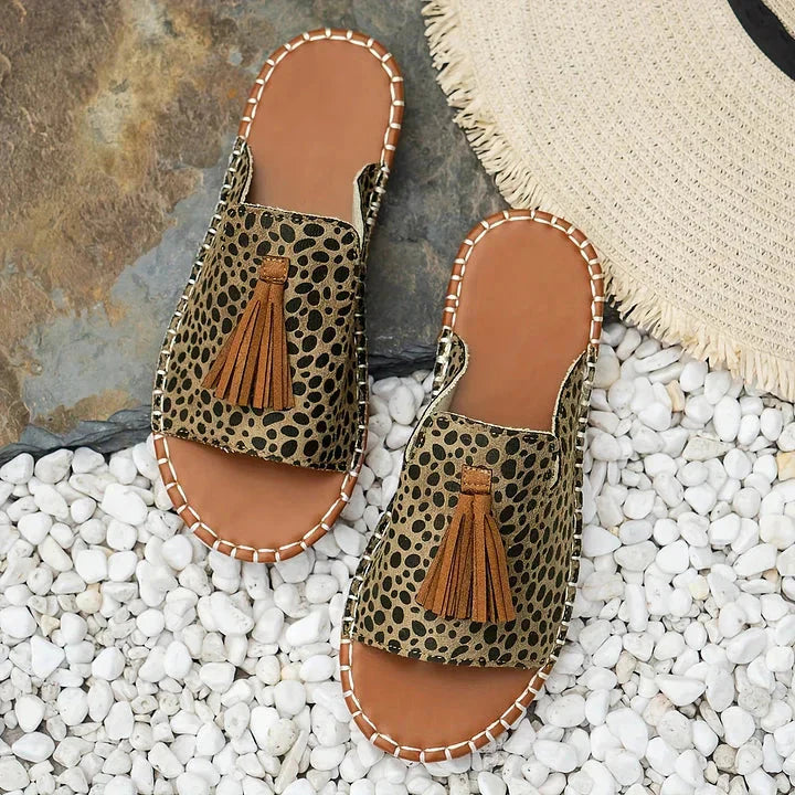 Top view of leopard patterned platform sandals with brown tassels and tan sole