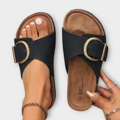 Top view of black and beige buckle slide sandals with cork sole