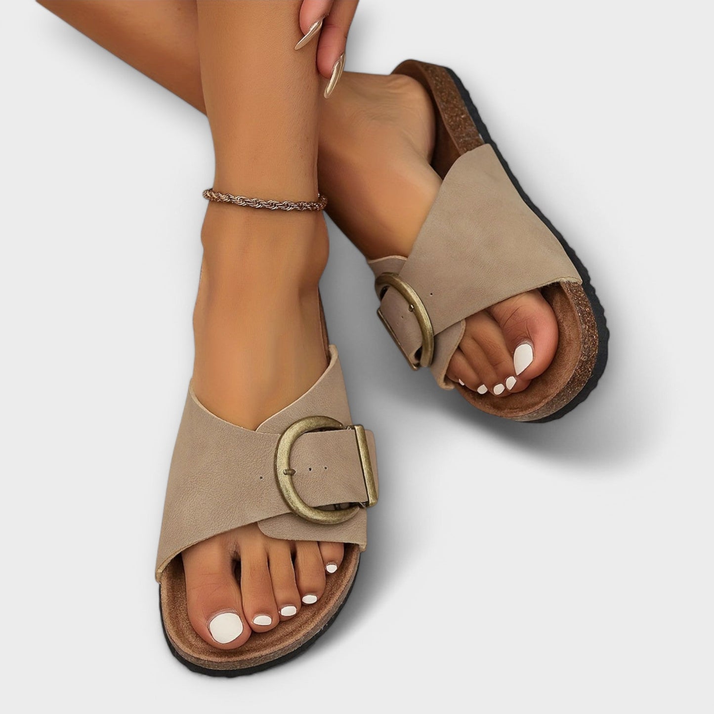 Beige buckle slide sandal with cork footbed on foot, side view