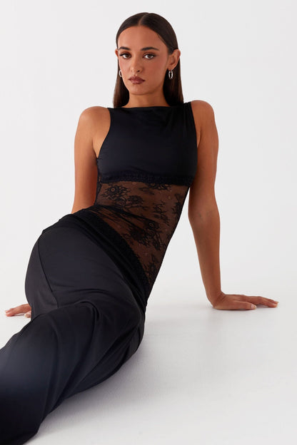 Black maxi dress with lace waist cutout detail, side view showing silhouette
