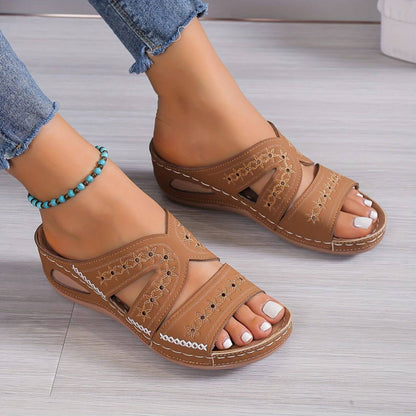 Tan embroidered wedge sandals with multi-strap design and decorative perforations