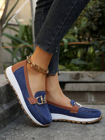 Navy canvas loafer with tan leather trim and gold chain hardware