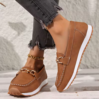 Tan leather loafers with gold chain accent and white sole, side profile view