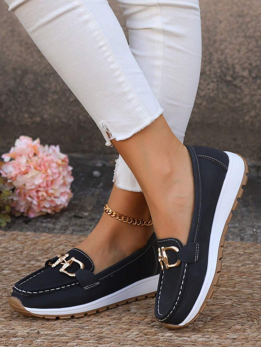 Black loafer with gold metal buckle hardware and white sole
