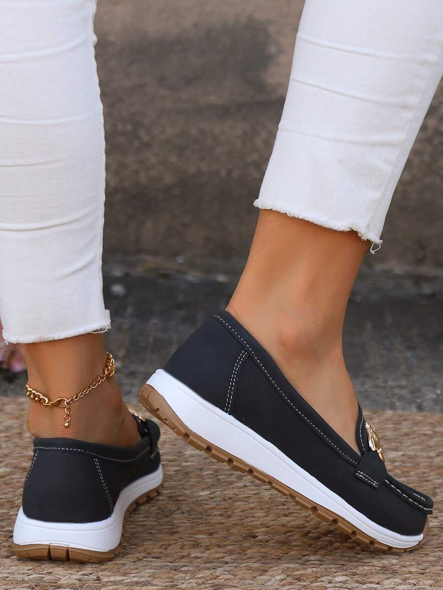 Black loafer with chunky gold chain hardware and white platform sole