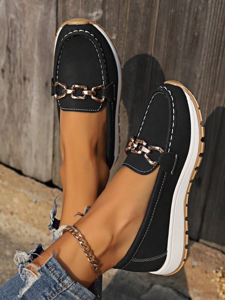 Black suede loafer with gold metal buckle and tan lug sole