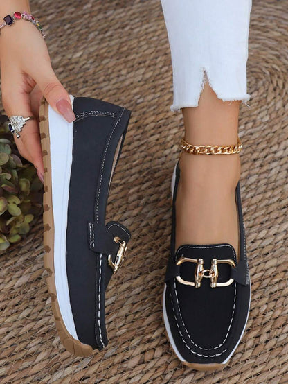Black loafer with gold chain hardware and white stitching detail