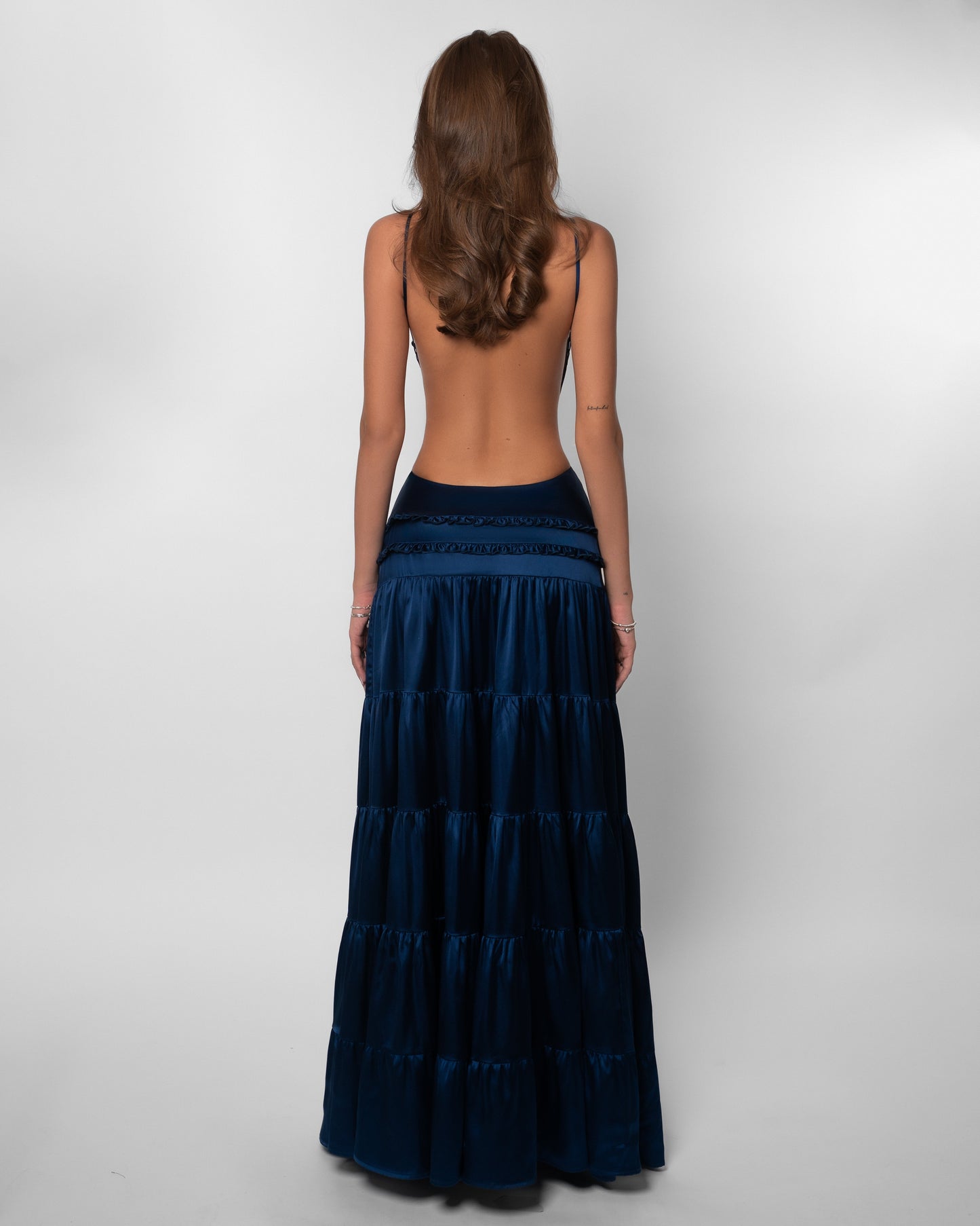 Back view of navy tiered maxi dress with open back design