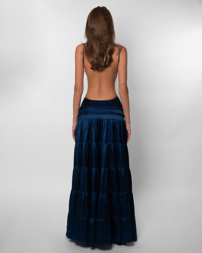 Back view of navy tiered maxi dress with open back design