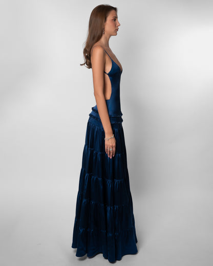 Side angle of navy v-neck maxi dress with open back and layered hem