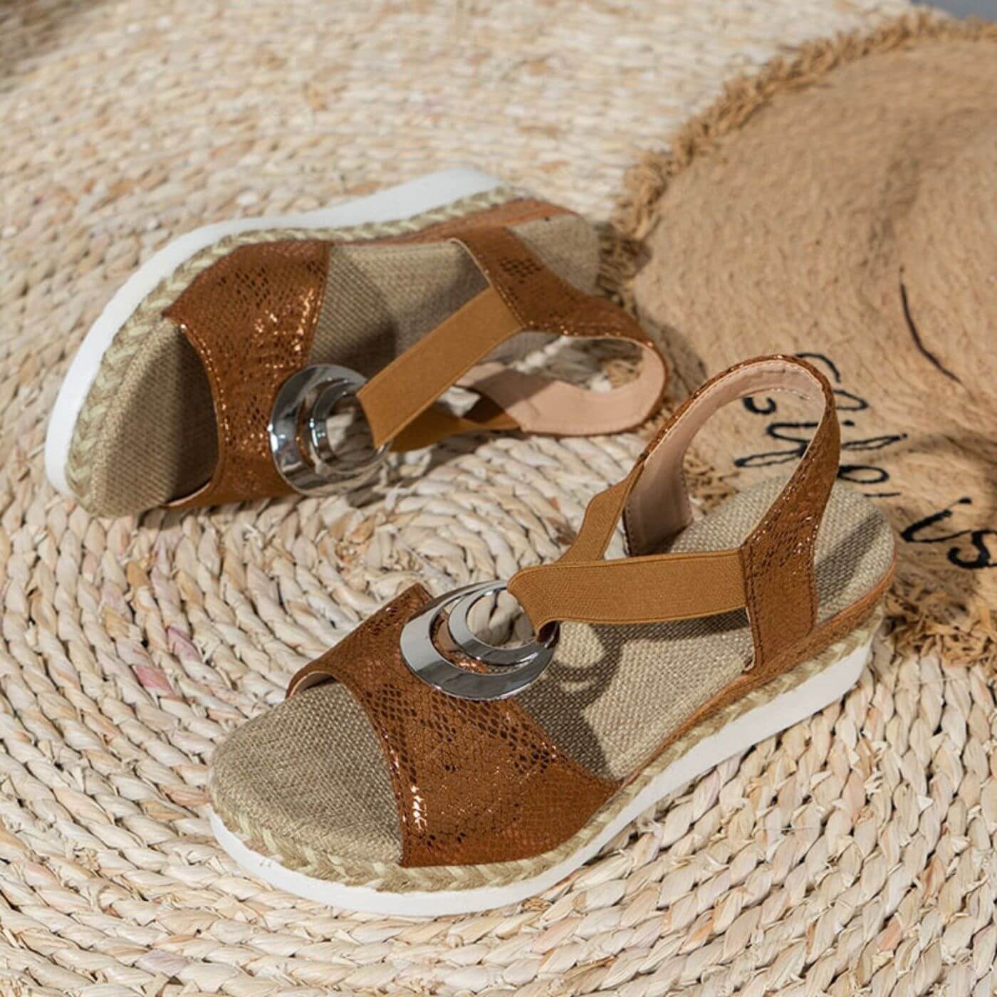 Tan and cream platform sandals with adjustable ankle strap and metal ring buckle on jute base