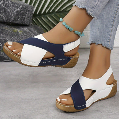 Navy and white platform sandals with adjustable back strap, worn on feet showing side view