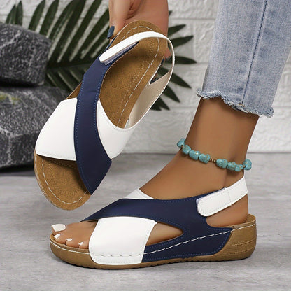 Navy and white platform sandals with adjustable back strap, held in hand showing sole detail