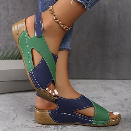 Green and navy platform sandals with adjustable back strap, worn on feet showing cross-strap design