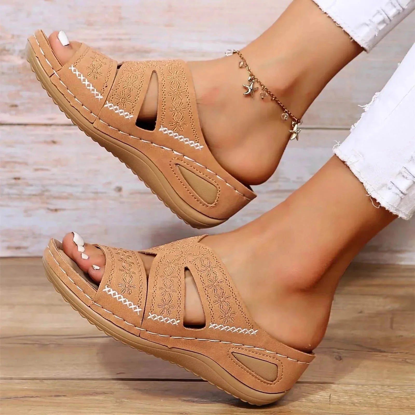Tan wedge platform slides with embroidered straps shown from above with white stitching detail