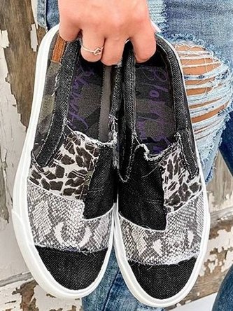 Overhead view of black and white animal print canvas slip-on sneakers with padded interior