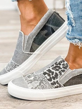 Angled view of animal print canvas sneaker with white rubber sole and mixed textures