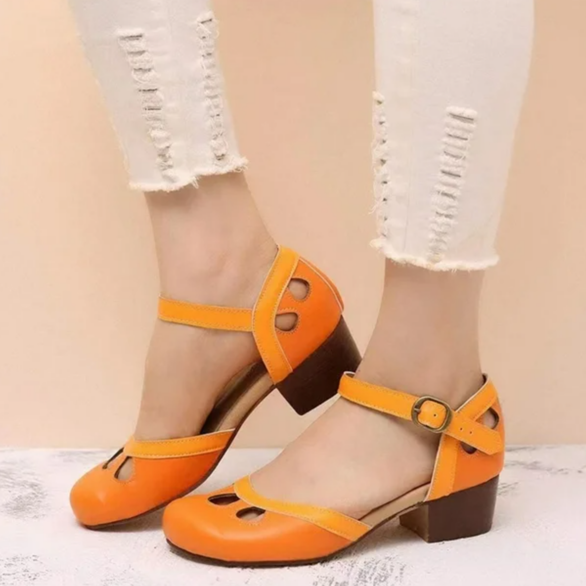 Bright orange Mary Jane sandals with low block heel and perforated toe design