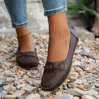 Brown perforated moc toe loafer flat with cushioned sole and decorative stitching