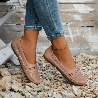 Beige perforated moc toe loafer flats with cushioned soles worn with rolled denim