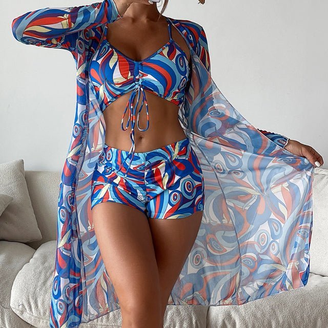 Women's crop set in blue, red, and white geometric print featuring tie-front crop top, shorts, and long sheer cardigan