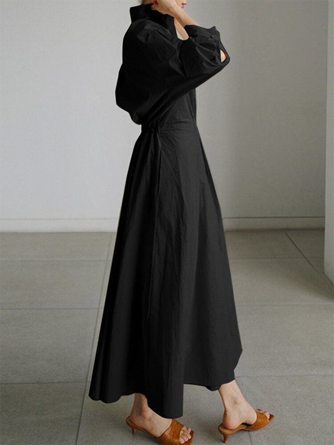 Side view of black puffed sleeve wrap dress showing dramatic sleeve volume