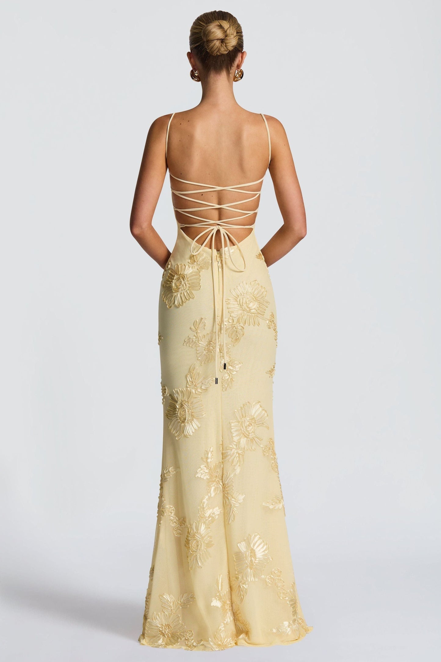 Back view of cream maxi dress with lace-up strappy back and gold embroidery
